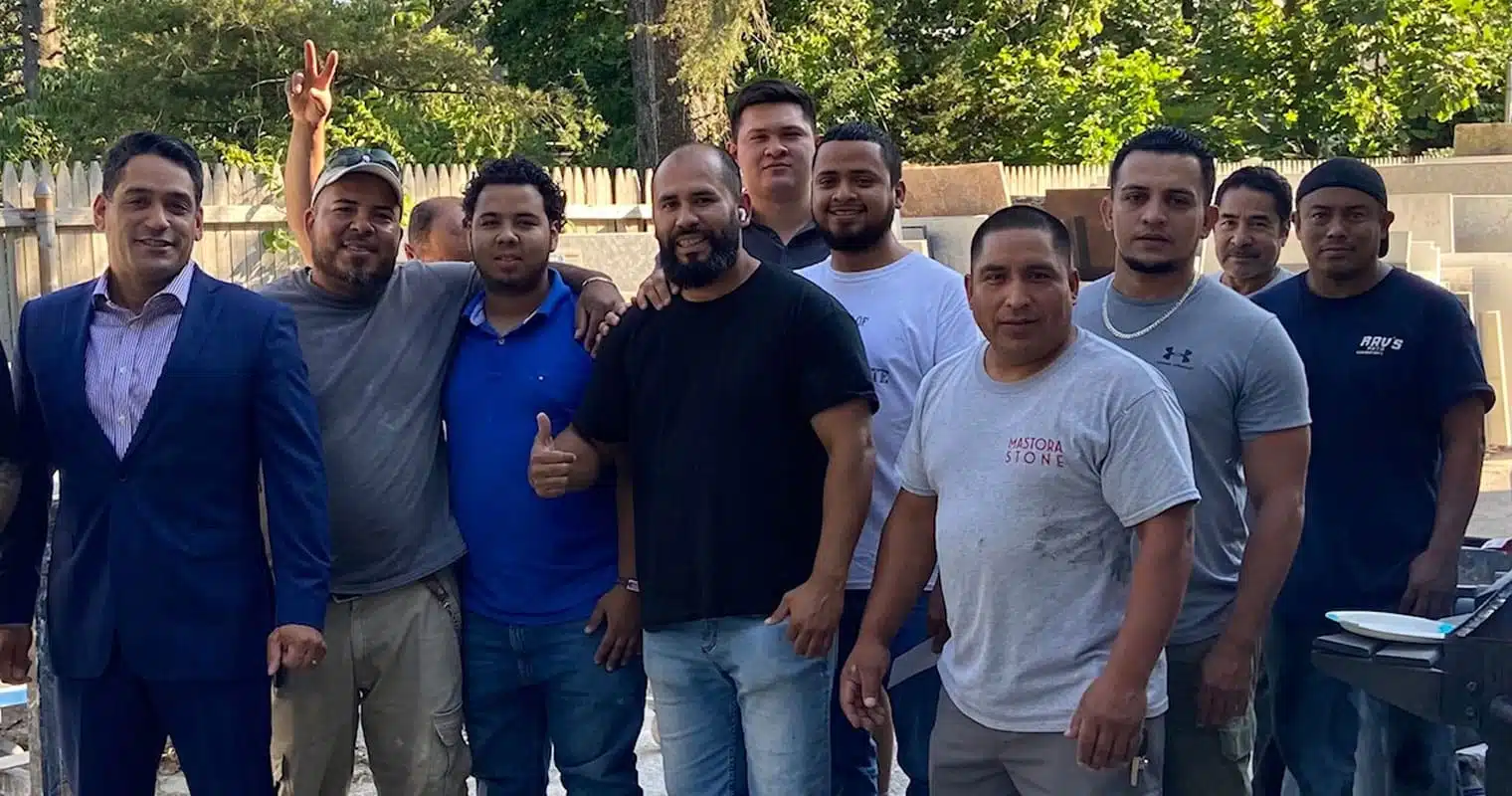 Marcus Monteiro junto a trabajadores hispanos de la construcción que ganaron su caso de horas extras impagas en Queens, NY
